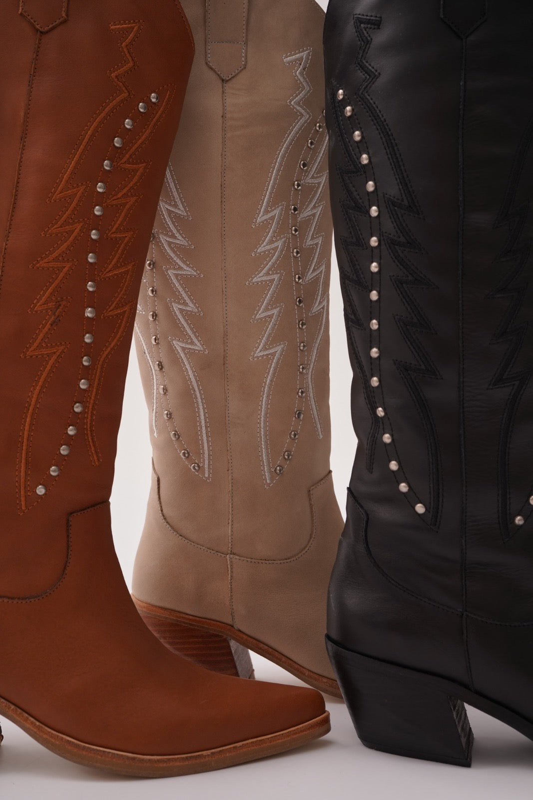Classic tall cowboy boots with pointed toes, angled block heels, and intricate tonal embroidery on the shaft. A timeless Western silhouette with a sleek, all-black finish for versatile, edgy styling.