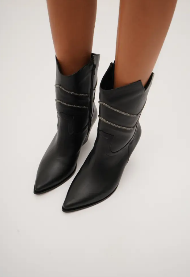 Sleek black mid-calf cowboy boots with pointed toes, angled block heels, and silver embroidered chevron stitching. These modern western boots blend classic style with a chic, minimalist edge.