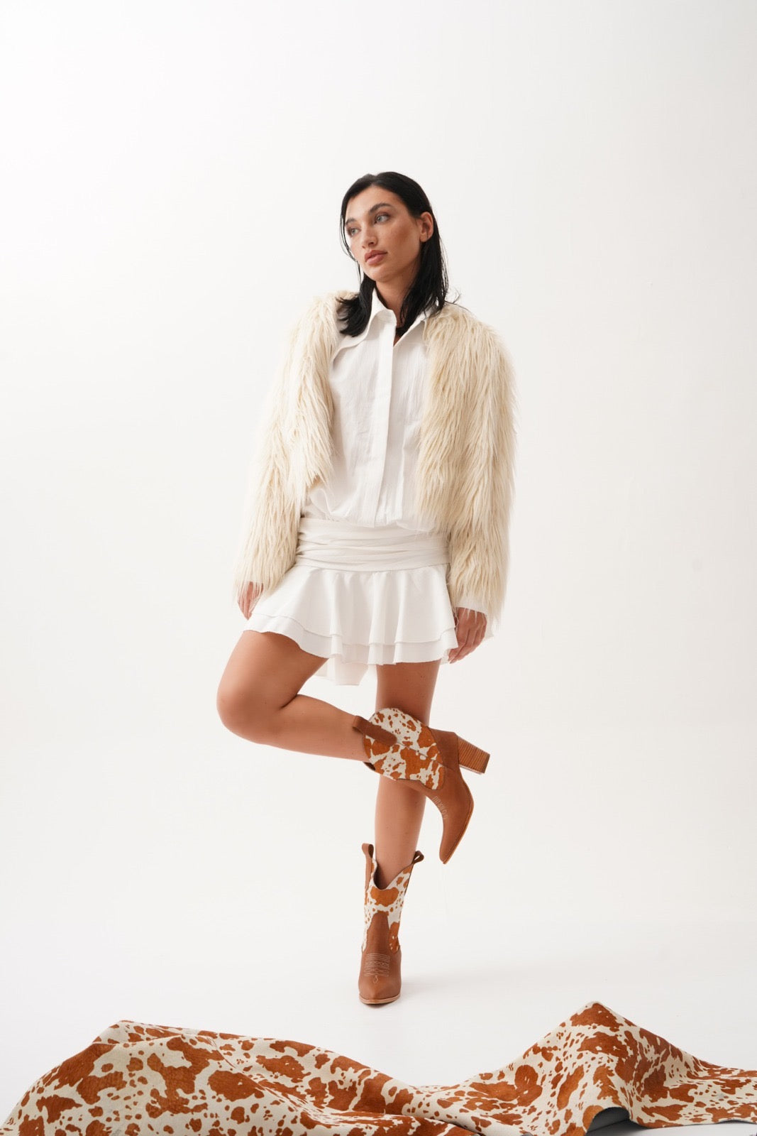 Rich tan leather ankle boots featuring warm orange-and-white cow-print uppers, wooden stacked heels, and engraved detailing. A bold Western statement for stylish day-to-night wear.