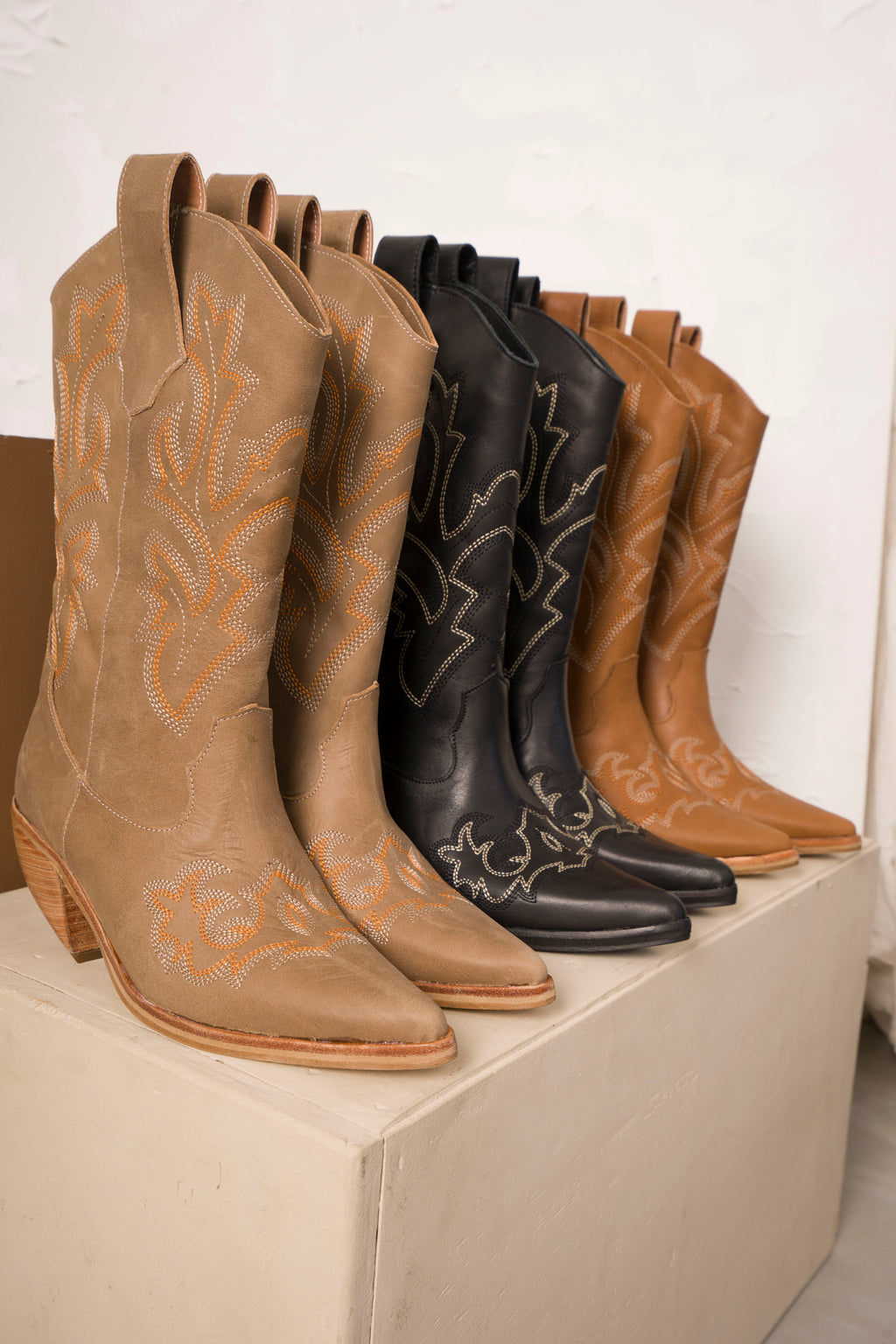 Classic mid-calf cowboy boots in rich tan leather, featuring intricate white Western stitching, pointed toes, and angled wooden block heels. A timeless rustic design perfect for everyday wear or elevated country-chic outfits.